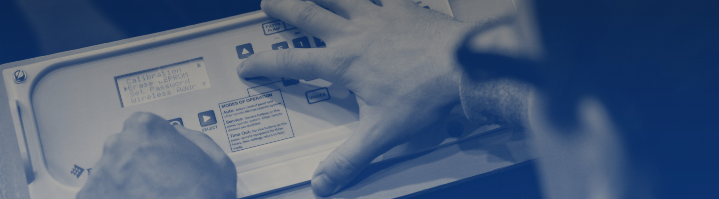 Blue tinted image of a man working on a pool module system. 