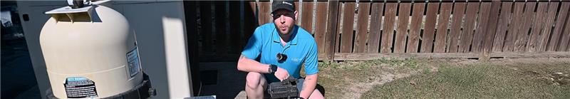 A man squatted down explaining how to change a pool filter.